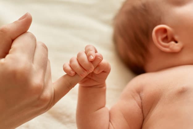 bebe tomando la mano de su madre en terapia ecmo