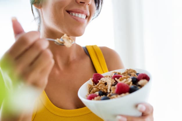 Mujer comiendo un tazón de cereal